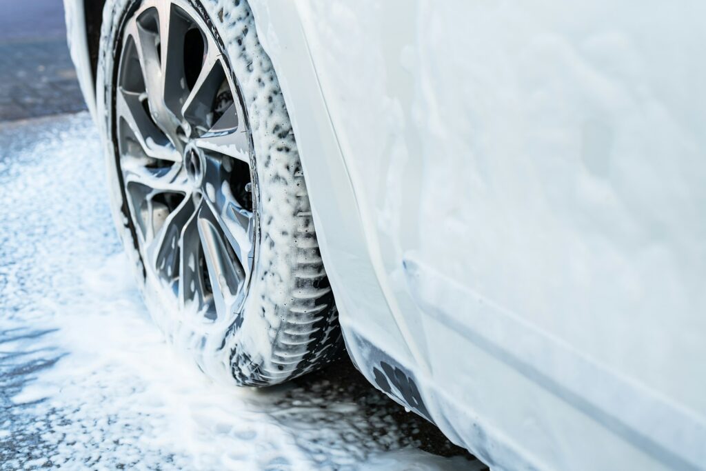 Car wash, white car, wash the car with foam at the car wash. Self-service car wash.